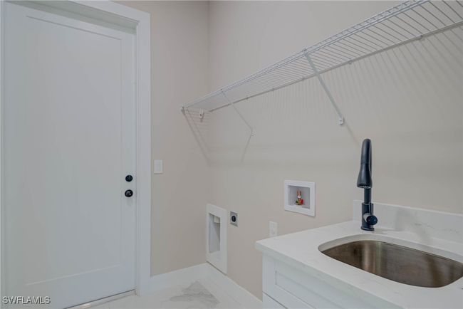 Clothes washing area featuring hookup for an electric dryer, marble finish floor, a sink, laundry area, and washer hookup | Image 18