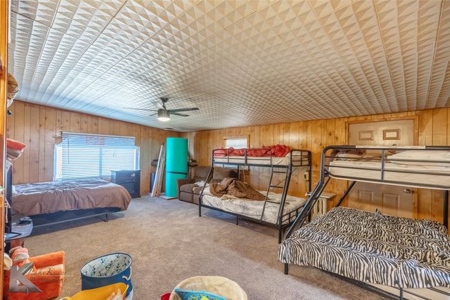 Carpeted bedroom featuring wooden walls | Image 26