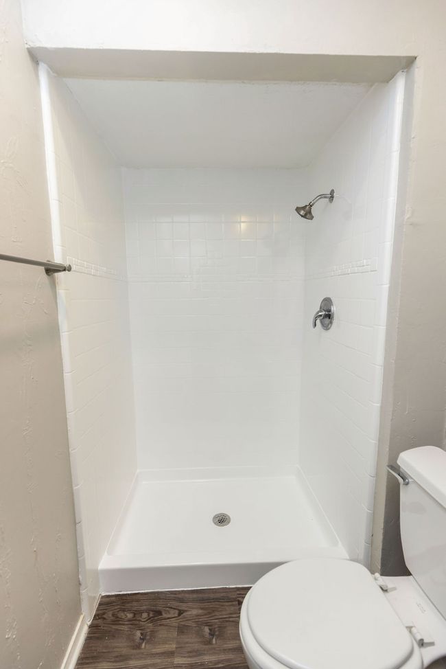 Full bathroom with toilet, a stall shower, and wood finished floors | Image 24