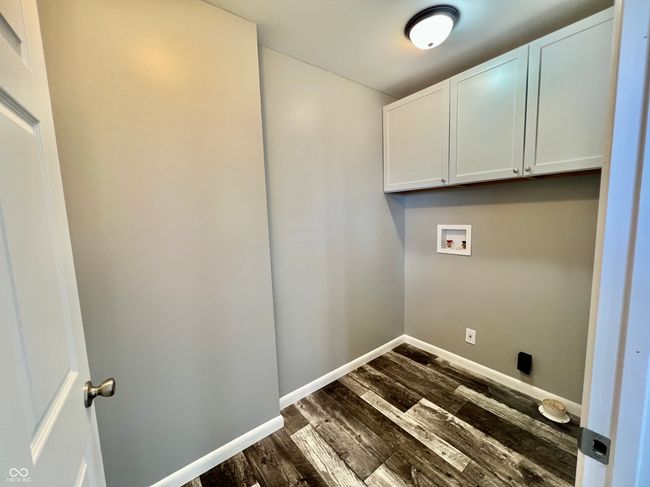 laundry area with cabinet space, baseboards, washer hookup, and dark wood-type flooring | Image 21