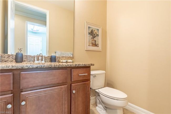 Tiled bedroom with ensuite bathroom, a tray ceiling, ceiling fan, and ornamental molding | Image 25