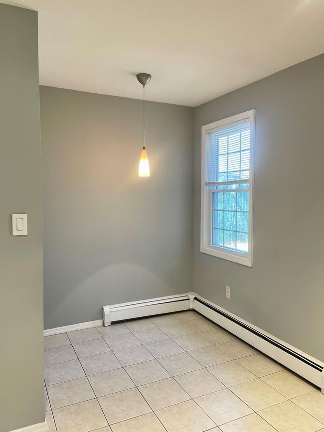 Unfurnished room with a baseboard radiator, baseboards, and light tile patterned flooring | Image 19