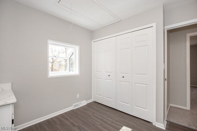 Unfurnished bedroom with dark wood-type flooring and a closet | Image 22