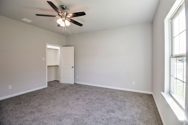 Empty room with a ceiling fan and carpet | Image 11