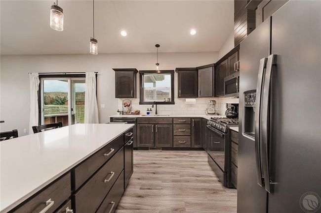Attention to details in the design of this chefs style kitchen with roll out drawers, ss appliances, natural gas range and dishwasher and easy clean subway tile backsplash. | Image 9
