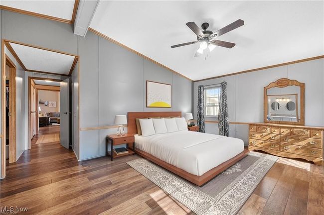 Bedroom with vaulted ceiling, crown molding, wood finished floors, and ceiling fan | Image 13