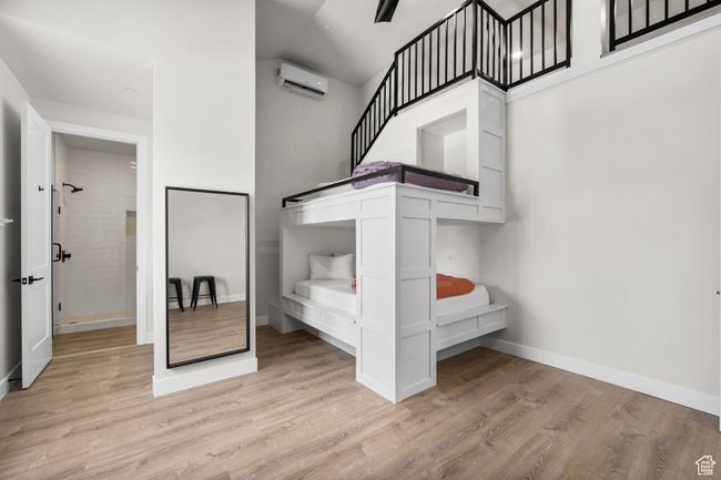 Unfurnished bedroom featuring light wood-type flooring and a wall mounted air conditioner | Image 37