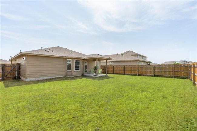 Rear view of house featuring a fenced backyard, a yard, and a patio area | Image 27