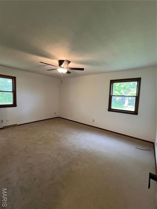 Empty room with a ceiling fan, baseboards, visible vents, and carpet floors | Image 10