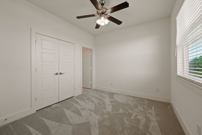 Unfurnished bedroom featuring baseboards, a closet, light colored carpet, and ceiling fan | Image 32