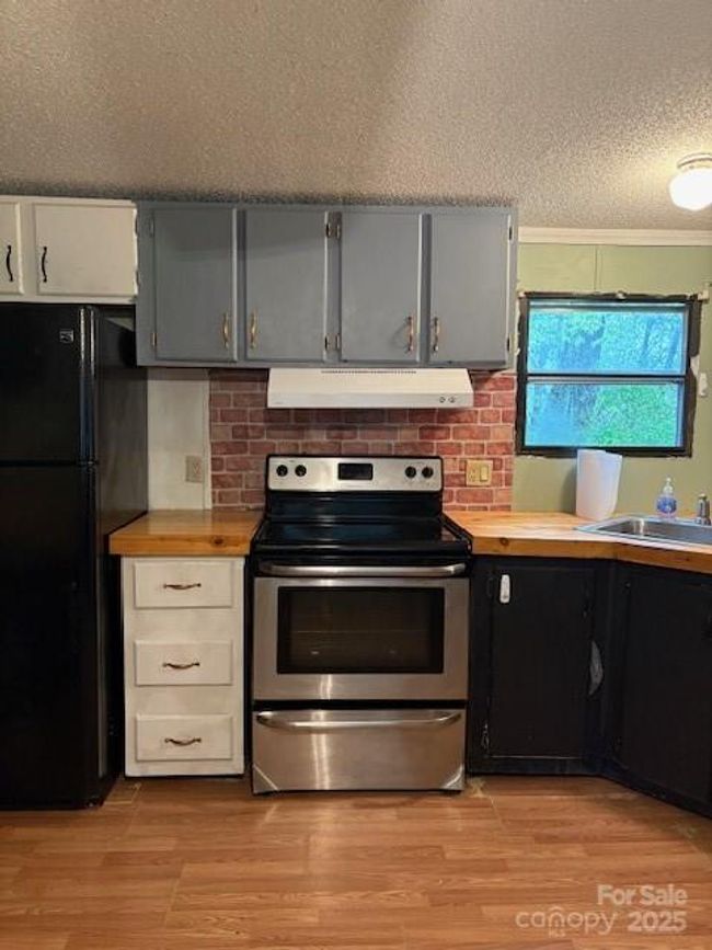Kitchen has smooth top range and refrigerator | Image 14
