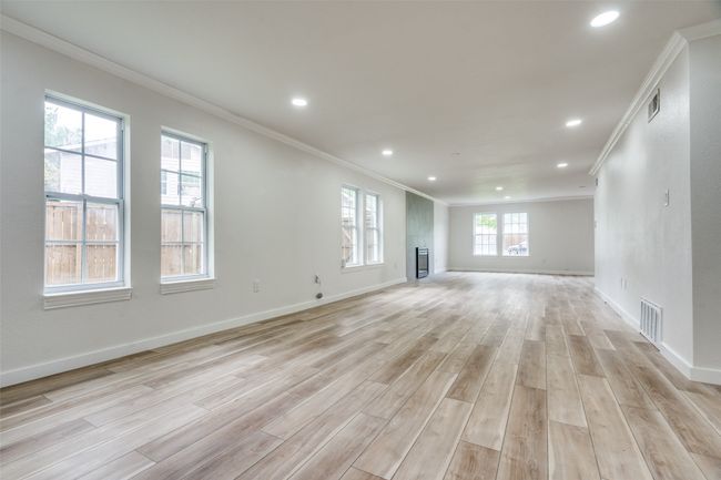 Unfurnished living room with crown molding, light wood-style floors, and recessed lighting | Image 8