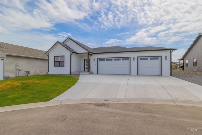View of front of house with an attached garage, driveway, a front yard, and board and batten siding | Image 37