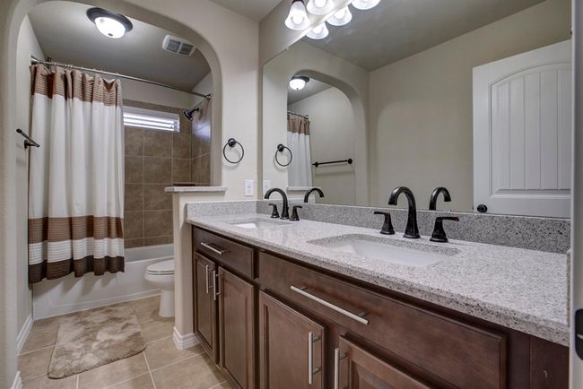 Bathroom featuring double vanity, shower / bath combination with curtain, and tile patterned flooring | Image 31