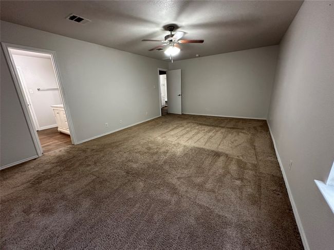 Carpeted spare room featuring a ceiling fan and baseboards | Image 31