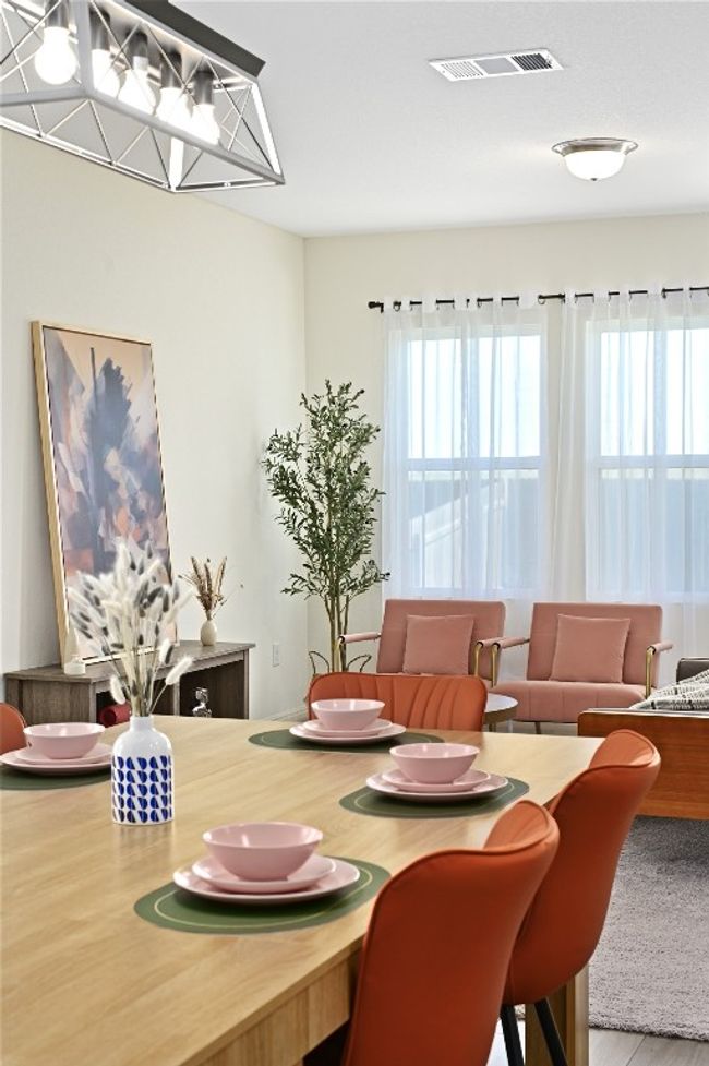 Dining room with wood finished floors and visible vents | Image 10