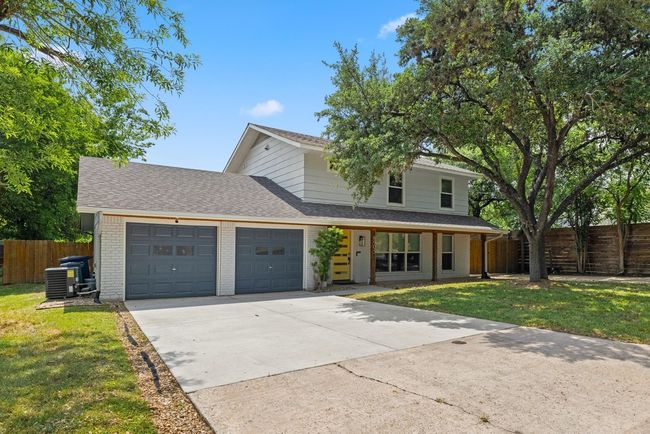 Traditional-style home with driveway, a porch, fence, a garage, and brick siding | Image 4