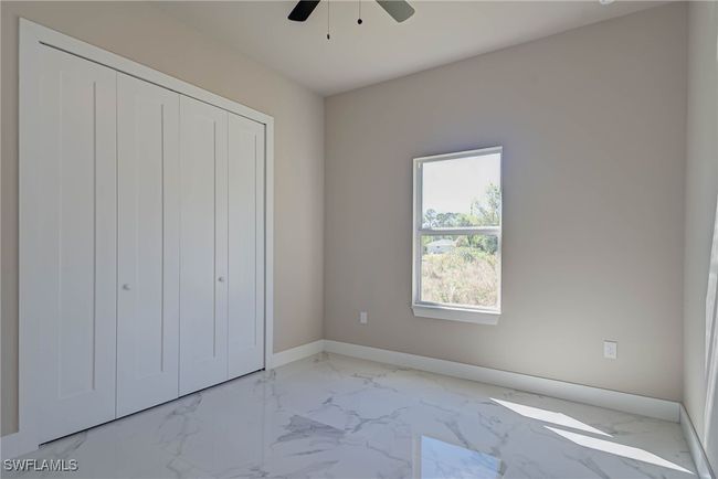 Unfurnished bedroom featuring a closet, marble finish floor, baseboards, and a ceiling fan | Image 17