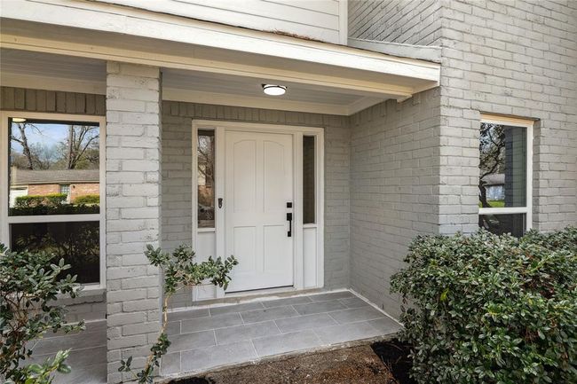 The harmonious front entryway has a distinguished covered front door. | Image 4