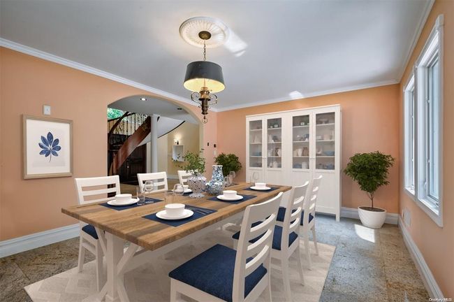 Dining area featuring a wealth of natural light, arched walkways, crown molding, and baseboards | Image 8