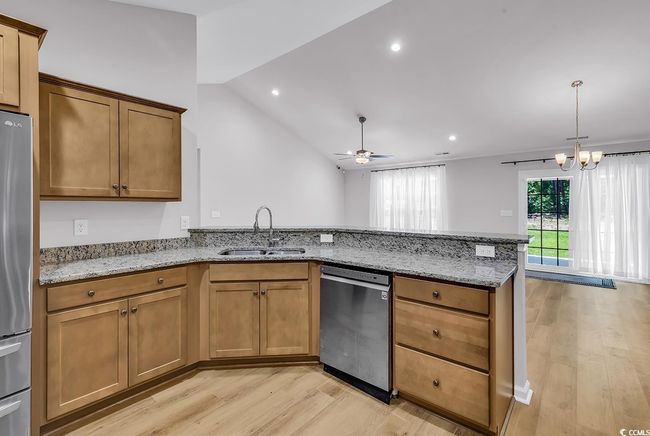 Kitchen with appliances with stainless steel finishes, a sink, light wood-style flooring, a peninsula, and ceiling​​‌​​​​‌​​‌‌​‌‌​​​‌‌​​‌‌​‌​​​​​‌ fan | Image 10