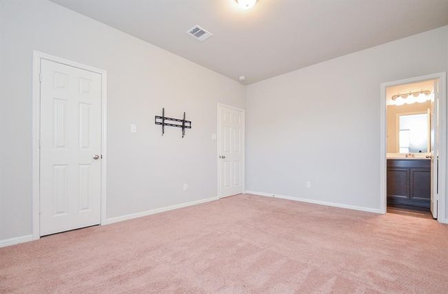 A spacious secondary carpeted bedroom enjoys its own ensuite bath. | Image 21
