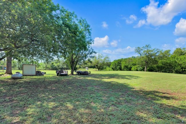 View of green lawn featuring a storage shed | Image 6
