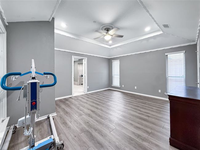 Exercise room with plenty of natural light, a raised ceiling, wood finished floors, and a ceiling fan | Image 29