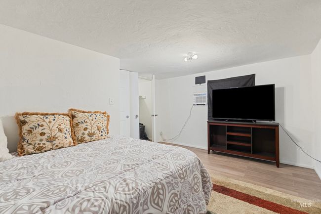 Bedroom featuring wood finished floors and a textured ceiling | Image 14