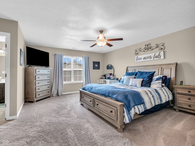 bedroom with baseboards, a ceiling fan, and light carpet | Image 24