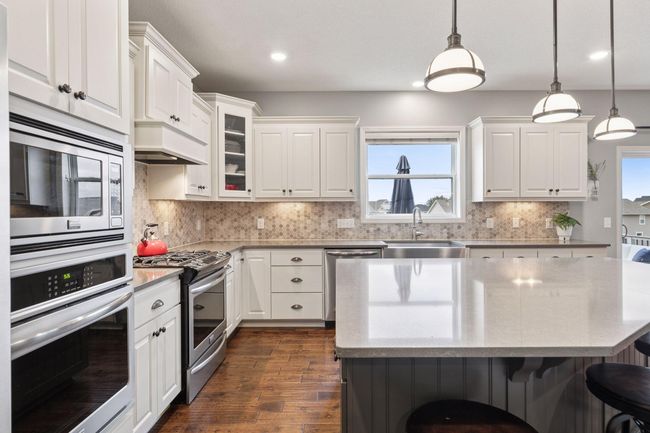 Massive island / breakfast bar. 2 ovens, tile backsplash. Well lit by recessed, overhead and under cabinet lighting | Image 13