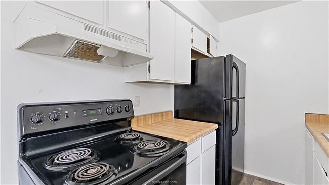 Kitchen with white cabinetry and black appliances | Image 21