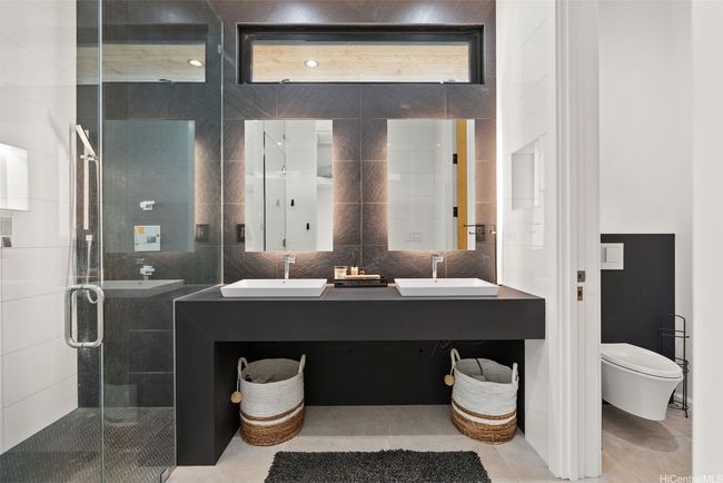Primary Bathroom with dual sinks, toilet room, shower, high ceilings, and a closet behind. | Image 11