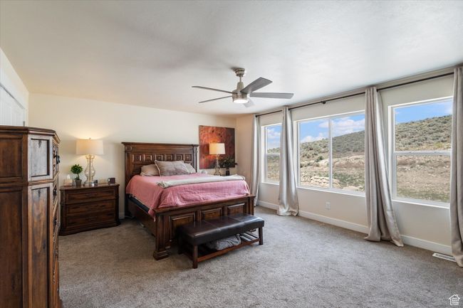 Bedroom with light carpet, ceiling fan, and amazing view | Image 17