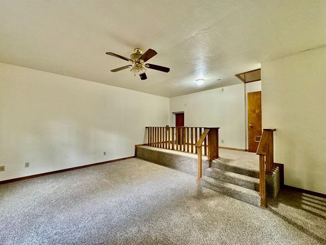 Carpeted empty room featuring ceiling fan and baseboards | Image 12