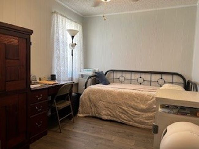 Bedroom with wood finished floors, ornamental molding, a textured ceiling, and ceiling fan | Image 16