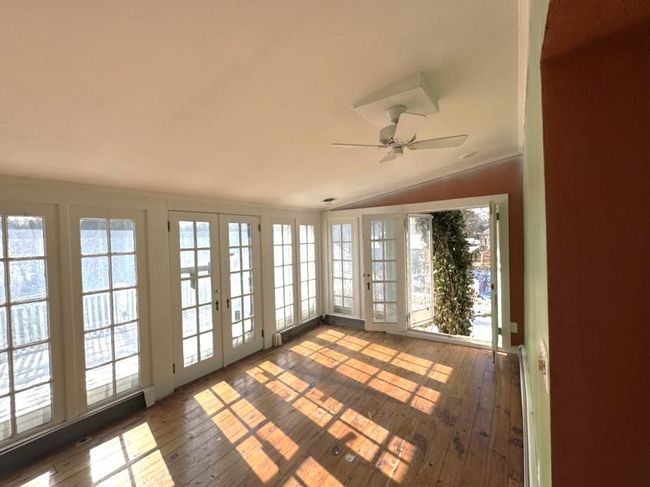 Unfurnished sunroom with vaulted ceiling, a ceiling fan, and french doors | Image 14