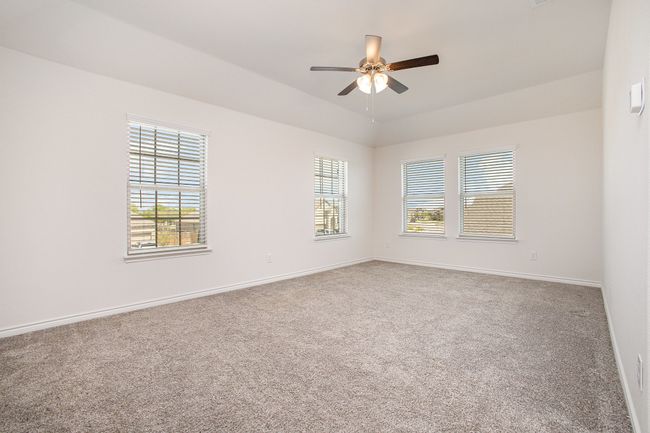 Carpeted empty room with baseboards, a ceiling fan, and plenty of natural light | Image 20