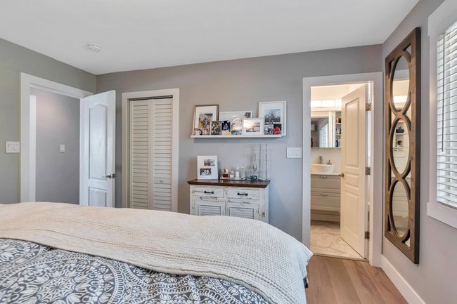Bedroom featuring a closet, a sink, baseboards, light wood-type flooring, and a dry bar | Image 19