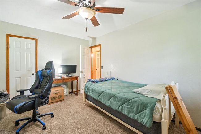 Bedroom featuring light carpet, a desk, and a ceiling fan | Image 27