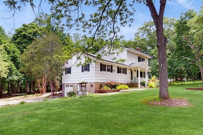 View of front of home with a chimney, an attached garage, and a large and flat front lawn! | Image 6