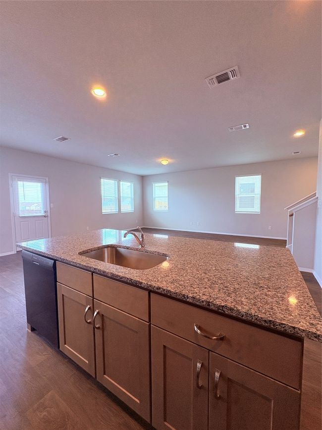 Kitchen with dishwasher, visible vents, light stone counters, and a sink | Image 10