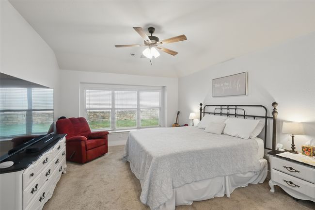 Bedroom featuring light carpet, ceiling fan, and vaulted ceiling | Image 24