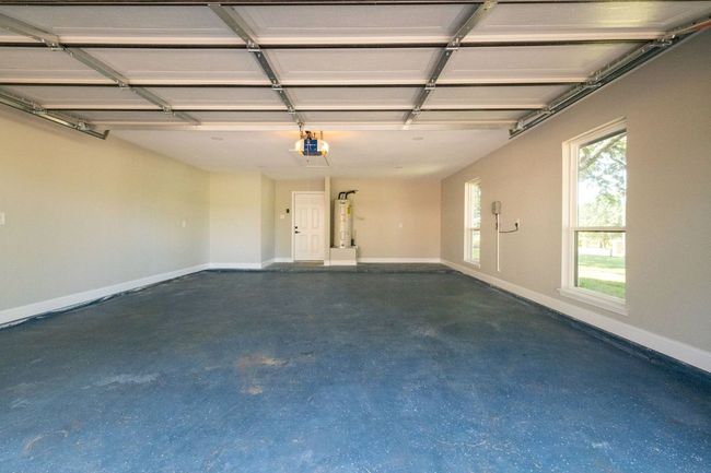 Garage featuring water heater and a garage door opener | Image 38