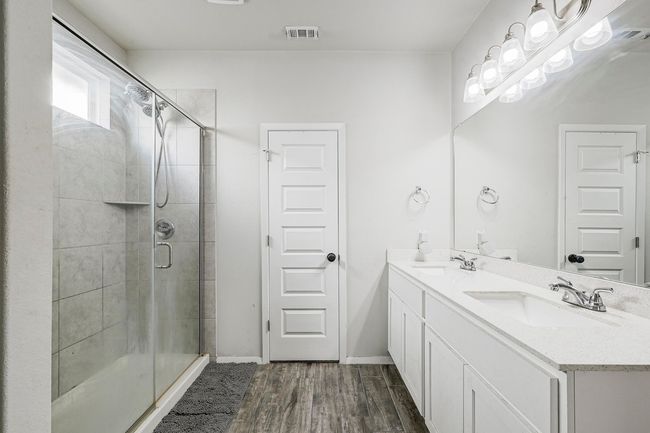 The primary bathroom features a comfortable walk-in shower and dual vanities. | Image 16
