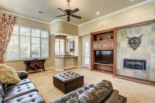 Living area with visible vents, a tiled fireplace, plenty of natural light, and light carpet | Image 12