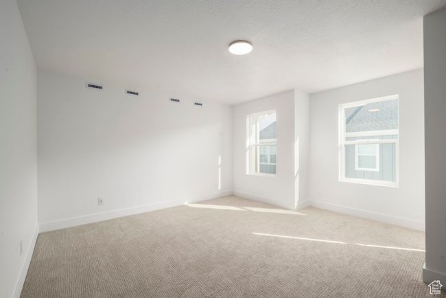 Unfurnished room with visible vents, light colored carpet, a textured ceiling, and baseboards | Image 11