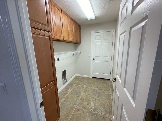 Laundry room with extra storage cabinets | Image 25