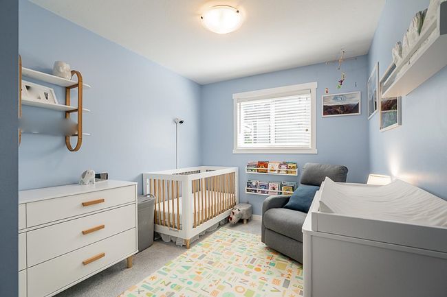 Bedroom with light colored carpet and a crib | Image 23