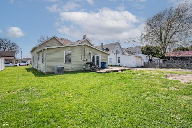 back of house featuring french doors, central AC unit, a chimney, fence, and a yard | Image 23